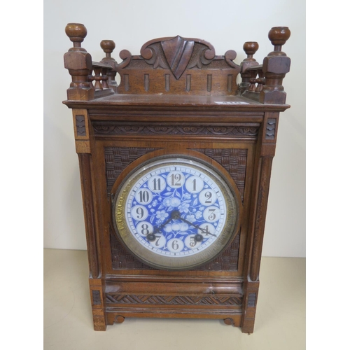 410 - A walnut mantle clock with a decorative dial, 36cm tall, striking on a gong, ticks but stops