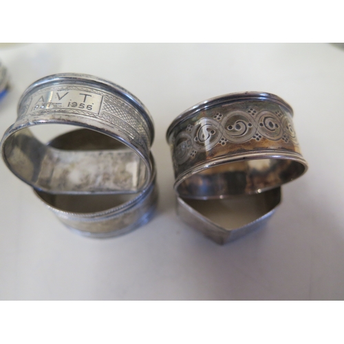 603 - Four silver napkin rings, a plated ring, a pair of silver salts, two shells with white metal surroun... 