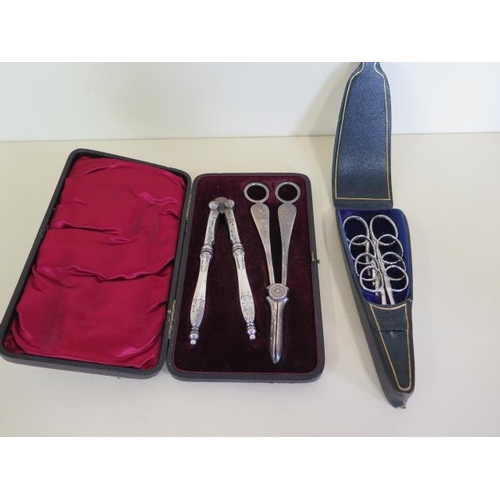 1249 - A set of four bright cut steel scissors in leather case, and a boxed set of plated nut crackers, and... 