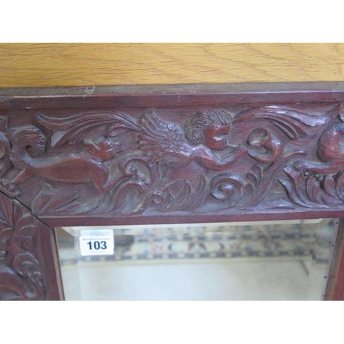 103 - A carved hardwood mirror with a herald and animal detail, 60x52cm