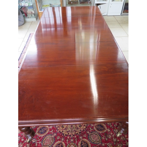 174 - A well restored 19th century pullout mahogany dining table with three leaves on turned legs, 73cm ta... 