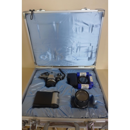 1231 - An Olympus OM 10 35mm camera kit, with three lenses