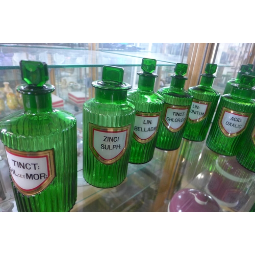 1271 - A collection of seventeen green glass chemist bottles, all with gilt edge labels, most generally goo... 