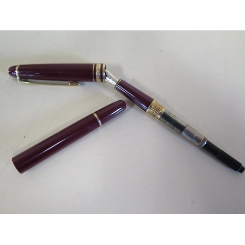 1273 - A Montblanc maroon plunger fountain pen with a 4810 14ct nib, 13.5cm long, generally good, not teste... 