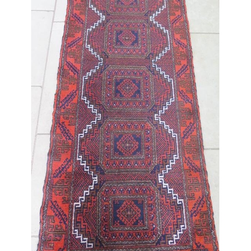 302 - A hand knotted woollen Belouch runner, 355cm x 85cm - in generally good condition