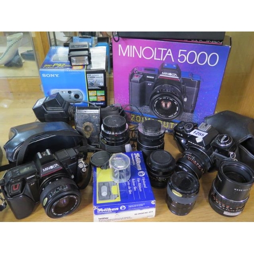 1255 - A collection of cameras, equipment and lenses including a Minolta 5000, Praktica EE2 and a bellows c... 