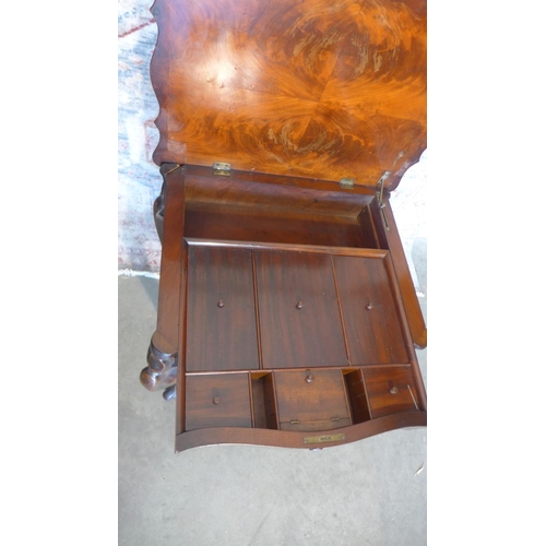 65 - A 19th century mahogany work box on shaped legs with a shaped lift up top revealing a sliding fitted... 