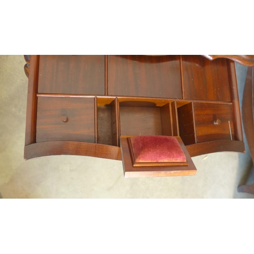 65 - A 19th century mahogany work box on shaped legs with a shaped lift up top revealing a sliding fitted... 