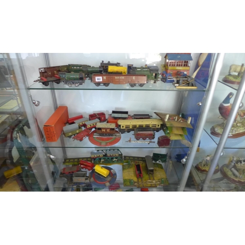 962 - A large quantity of O gauge tin plate railway rolling stock including some buildings and locos. All ... 