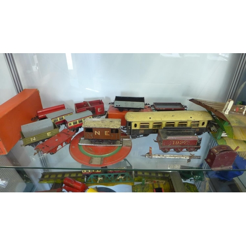 962 - A large quantity of O gauge tin plate railway rolling stock including some buildings and locos. All ... 