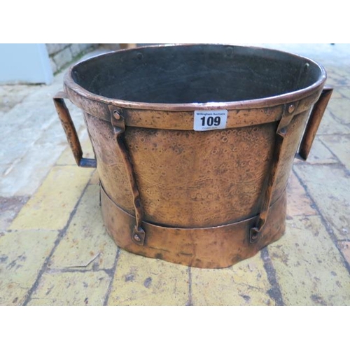 109 - An Arts and Craft copper twin handled log bin, 25cm tall x 42cm wide