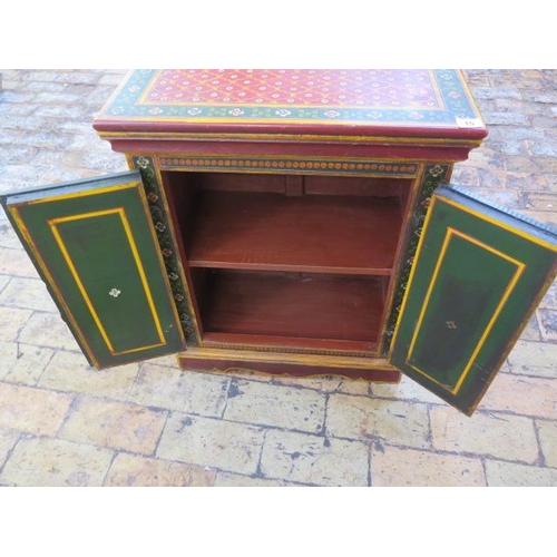 15 - A small continental decorative painted two door cupboard, 67cm tall x 54cm x 31cm
