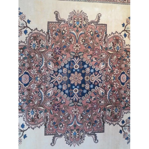 252 - A large red ground rug with wide foliate border, 3.1m x 2.15m, signs of wear to edges and general ag... 