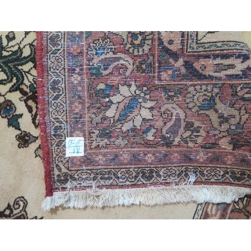 252 - A large red ground rug with wide foliate border, 3.1m x 2.15m, signs of wear to edges and general ag... 