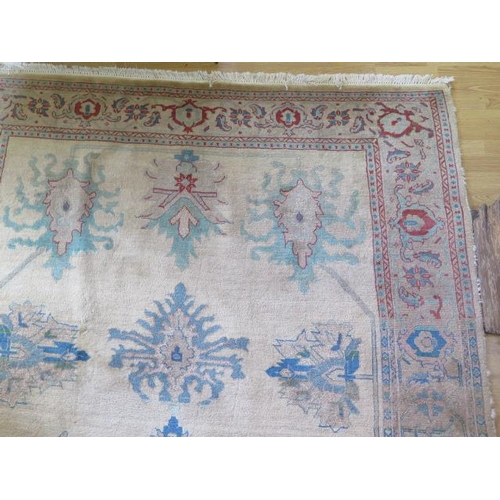 253 - A cream ground rug with wide foliate border, 3m x 2.03m, two thirds wide heavy sun fading and small ... 
