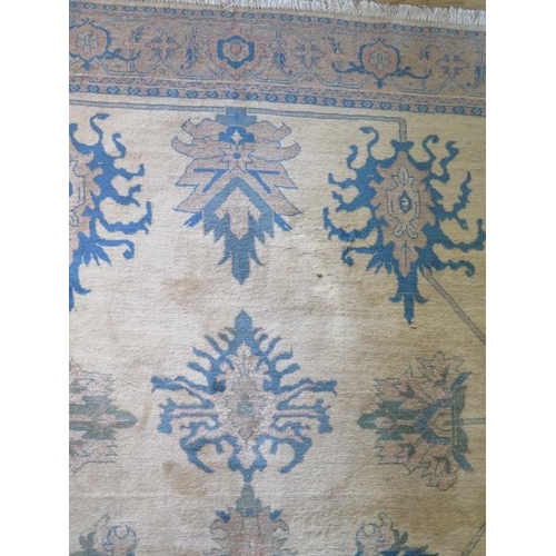 253 - A cream ground rug with wide foliate border, 3m x 2.03m, two thirds wide heavy sun fading and small ... 