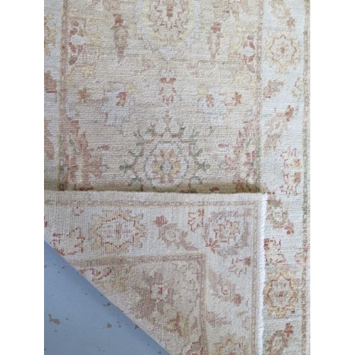 258 - A hand woven woollen rug with cream ground with overall foliate decoration, 1.9m x .78m, minor wear ... 