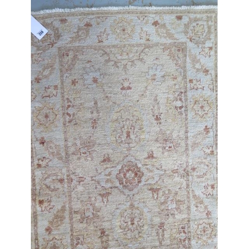 258 - A hand woven woollen rug with cream ground with overall foliate decoration, 1.9m x .78m, minor wear ... 