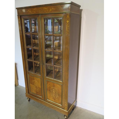 50 - A French 19th century rosewood inlaid bookcase, the glazed doors opening to reveal five internal she... 