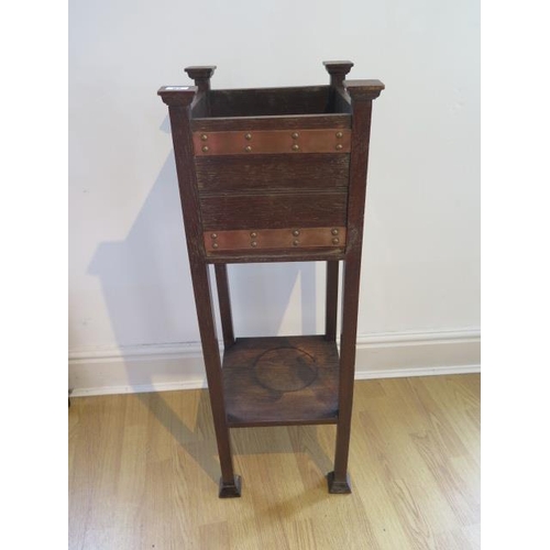 62 - An oak Arts and Craft plant stand with copper banding, 93cm tall x 33cm square, some water staining ... 
