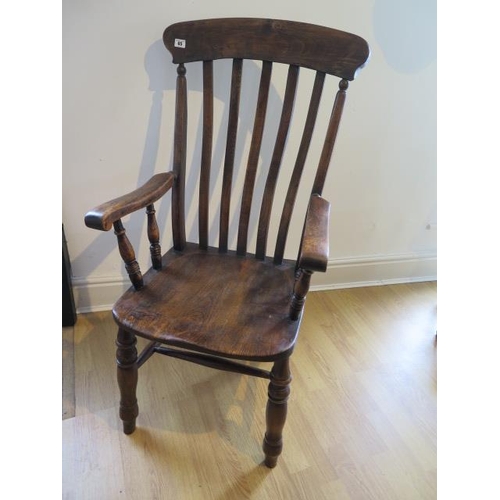 65 - A 19th century ash and elm elbow chair, some movement to joints and old worm but a good colour