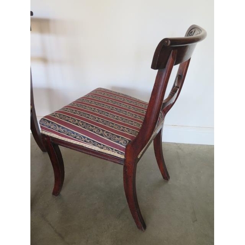 76 - A set of four Regency mahogany bar back dining chairs with upholstered seats and fluted sabre front ... 