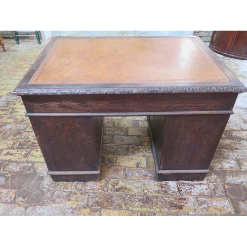 77 - An oak kneehole writing desk with tooled leather top and ornate 'Green Man' carved drawers, 107cm wi... 