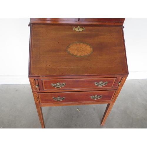 78 - An Edwardian inlaid mahogany two drawer bureau bookcase with a fitted interior standing on square ta... 