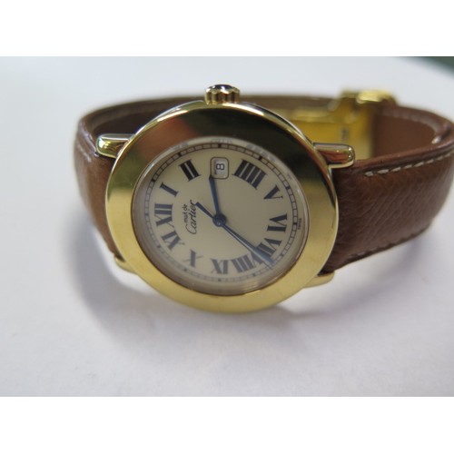 937 - A Cartier gold plated wristwatch 'Must de Cartier' with date aperture and brown leather strap in a l... 