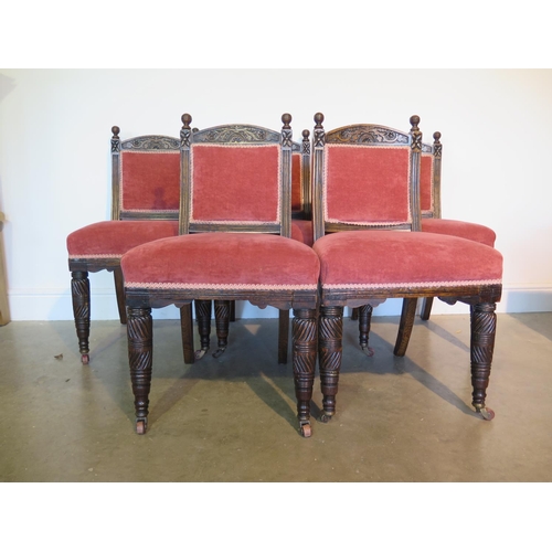 125 - An early 20th century set of five oak and upholstered dining chairs with foliate carved crest and fr... 