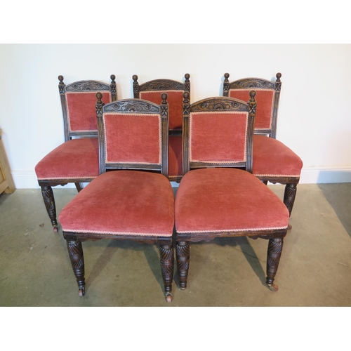 125 - An early 20th century set of five oak and upholstered dining chairs with foliate carved crest and fr... 