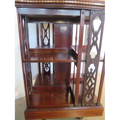 131 - A James Shoolbred mahogany and inlaid revolving bookcase with serpentine shaped square top on a revo... 