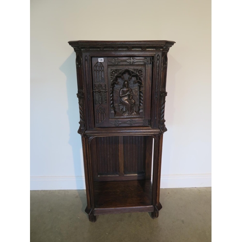 135 - A 19th century Gothic oak tall cupboard with carved figural door over a single under tier, 137cm tal... 