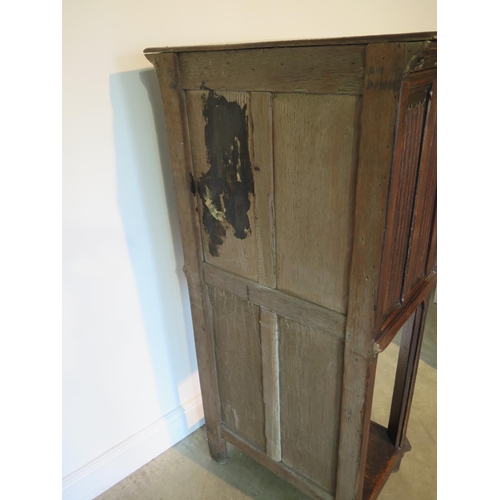 135 - A 19th century Gothic oak tall cupboard with carved figural door over a single under tier, 137cm tal... 