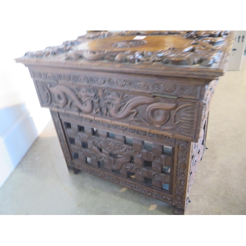 87 - A 19th century Chinese hardwood work box with hinged lid and all over carved dragon detail over a si... 