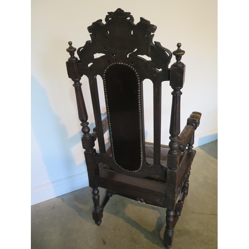 82 - A 19th century oak throne chair, the crested rail with carved lion and unicorn over a brown leather ... 