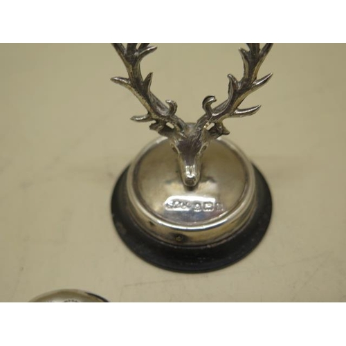 611 - A silver petrol lighter, a silver stags head menu holder and a silver cheroot holder case, all gener... 