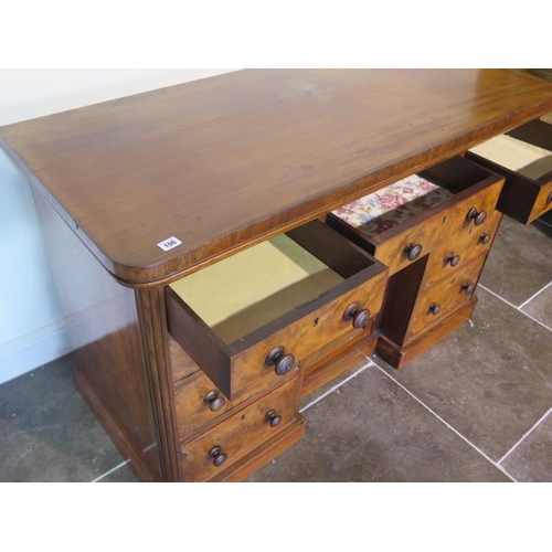 100 - A Victorian mahogany nine drawer desk / dressing chest with a central cupboard, 82cm tall x 127cm x ... 