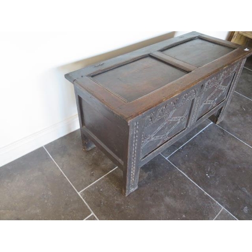 105 - An 18th century oak coffer with a carved front, 62cm tall x 117cm x 50cm, general wear consistent wi... 