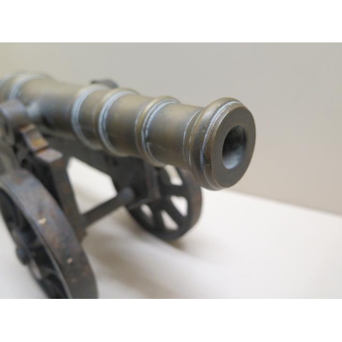 1078 - An ornamental brass cannon on cast iron carriage, 46cm long, some pitting but generally good