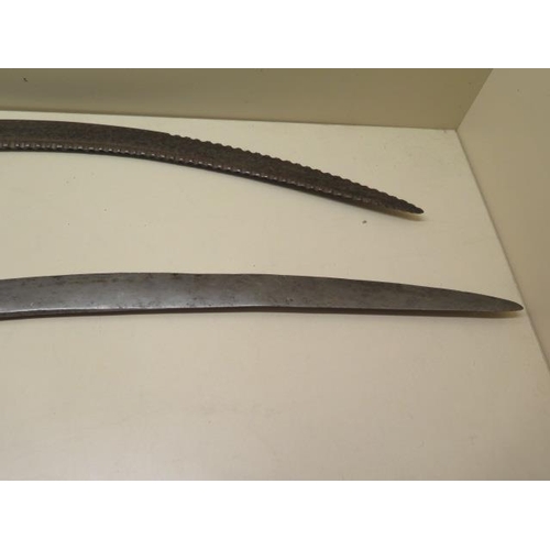 1096 - Two Indian Talwar swords, one with serrated blade, 93cm and 85cm long, both with pitting and some we... 