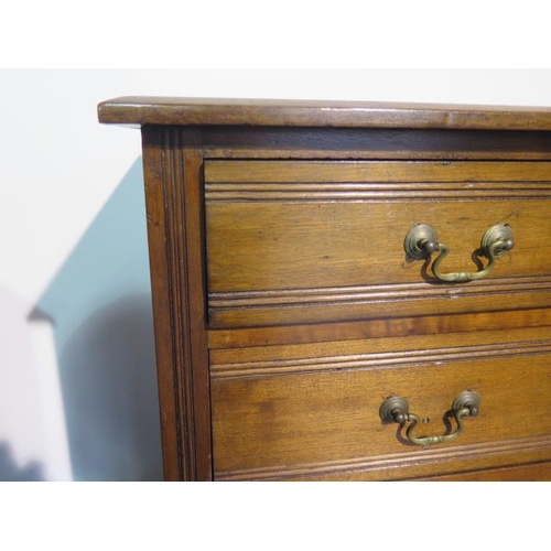 112 - A pair of late Victorian or Edwardian walnut bedside chests each with four graduated drawers with sw... 