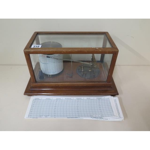 210 - A Tycos barograph retailed by Harrods Ltd Opticians London, 36cm x 22cm x 19cm tall, with spare char... 