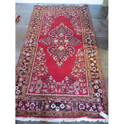 270 - A hand knotted woollen rug with a red field, 280cm x 140cm, generally good condition