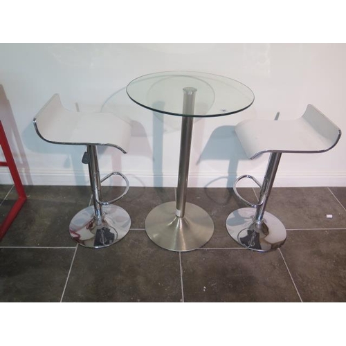 37 - A glass top bar table, 91cm tall x 60cm diameter with two white laminated gas lift stools, some usag... 