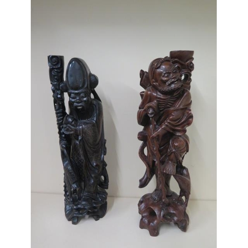 404 - Two Oriental carved rootwood figures, one with white metal inlay, 60cm  and 59cm tall, both with goo... 