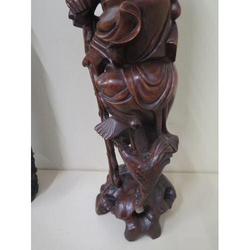 404 - Two Oriental carved rootwood figures, one with white metal inlay, 60cm  and 59cm tall, both with goo... 