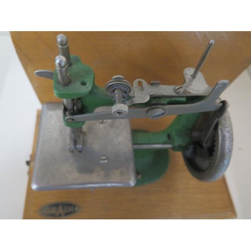 431 - A small sewing machine by Grain, working with case, measures 22cm tall