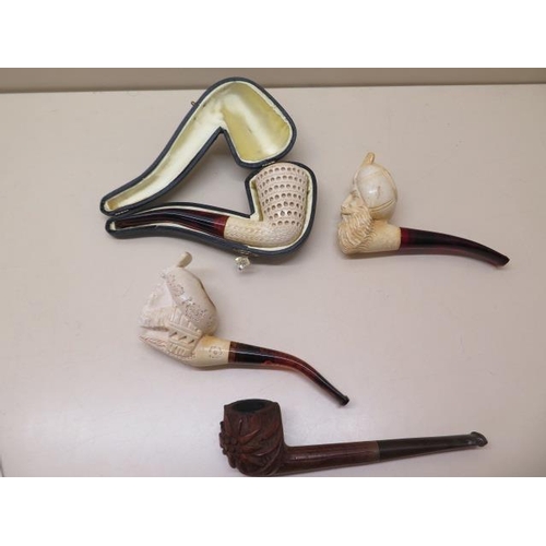 439 - A collection of four pipes to include two Meerschaum Turkish head pipes, a cased pierced reticulated... 