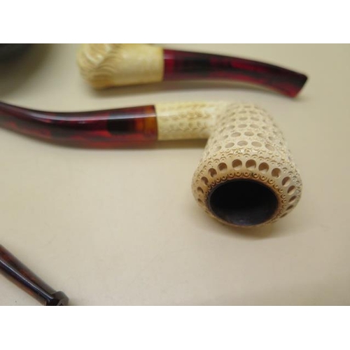 439 - A collection of four pipes to include two Meerschaum Turkish head pipes, a cased pierced reticulated... 